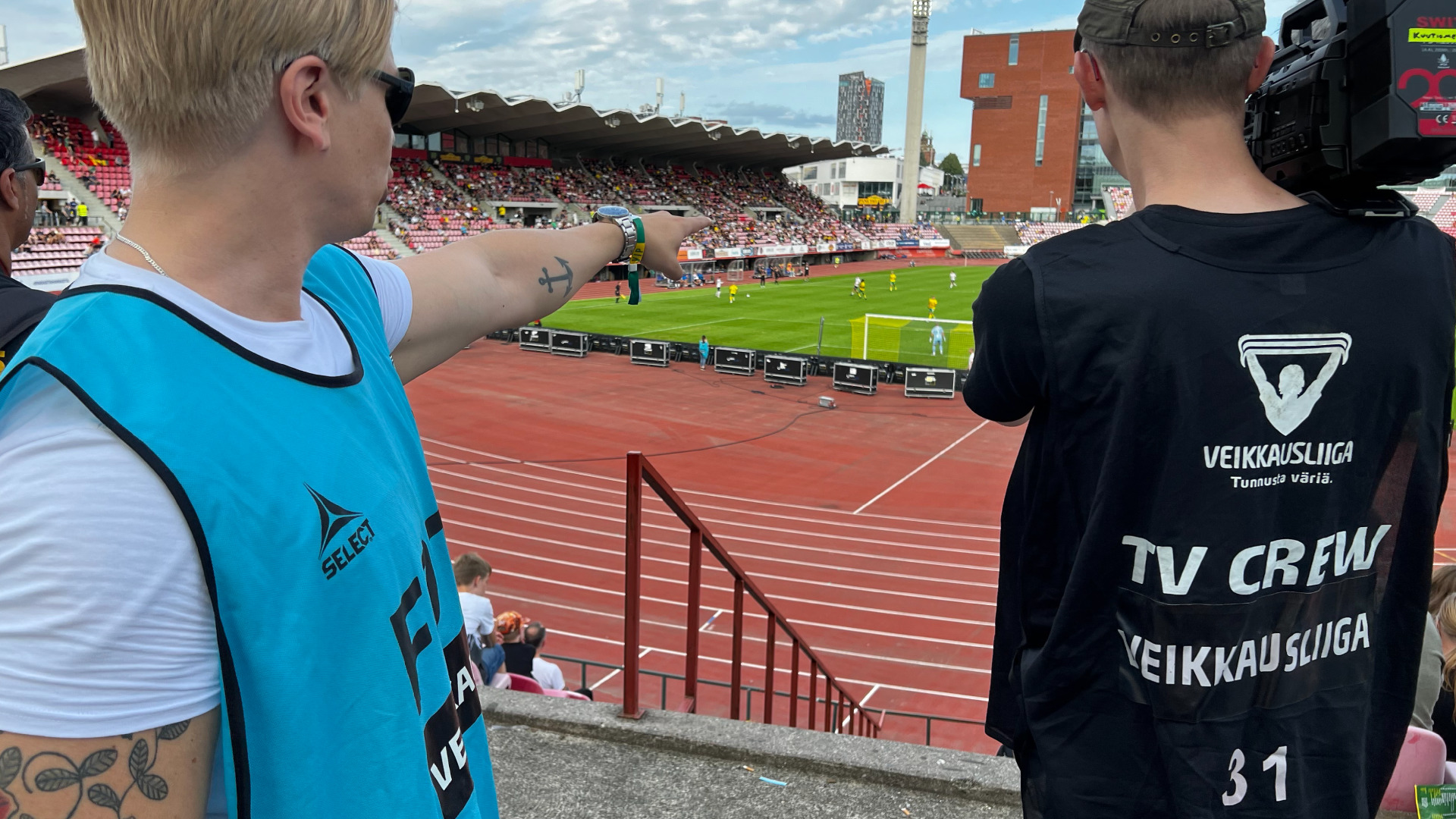 Valokuvassa Mainostoimisto Värikkään videotuottaja Joni Järvinen ohjaamassa videokuvaajaa, joka videokuvaa jalkapallo-ottelua